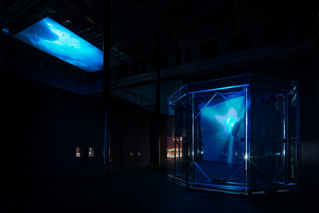 Exhibition view of *Midnight Zone* by Julian Charrière, Kunstmuseum Wolfsburg (14 March – 12 July 2026) Julian Charrière, *Midnight Zone*, 2025, Fresnel lens, mirror foil, transducer, haze, glass, steel structure, multichannel sound installation, 40 min., dimensions variable; Albedo, 2025, 1-channel video (4K), 16:10 aspect ratio, color, 3D ambisonic soundscape, 42:20 min., © der Künstler / VG Bild-Kunst, Bonn 2026, Photo and background: Jens Ziehe