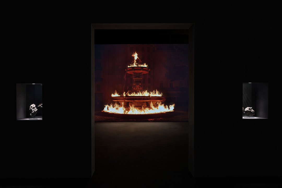 Exhibition view of *Midnight Zone* by Julian Charrière, Kunstmuseum Wolfsburg (14 March – 12 July 2026) Julian Charrière, *And Beneath It All Flows Liquid Fire*, 2019, 1-channel video (UHD), 16:10 aspect ratio, color, stereo sound, continuous video loop; *Metamorphism*, 2016, synthetic lava, molten computer waste, steel, white glass, © the artist / VG Bild-Kunst, Bonn 2026, Photo: Jens Ziehe