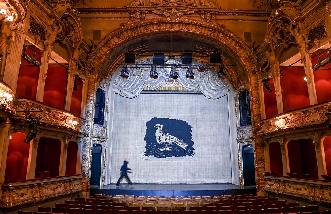 Das Berliner Ensemble hat einen Vorhang aus den Zeiten Bertolt Brechts mit einer Friedenstaube wieder aufgehängt. Als Brecht in den 1950ern mit dem Berliner Ensemble das Theater am Schiffbauerdamm bezogen habe, habe er als Mahnung gegen den Krieg einen Theatervorhang mit einer Friedenstaube Pablo Picassos hängen lassen, teilte das Theater mit. Jetzt hängt der Originalvorhang als Zeichen der Solidarität mit der Ukraine wieder im Großen Haus. Foto: picture alliance/dpa/dpa-Zentralbild | Jens Kalaene